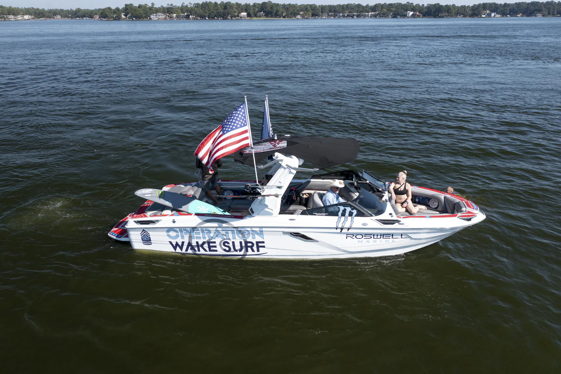 A wakesurf boat with an American flag on it.