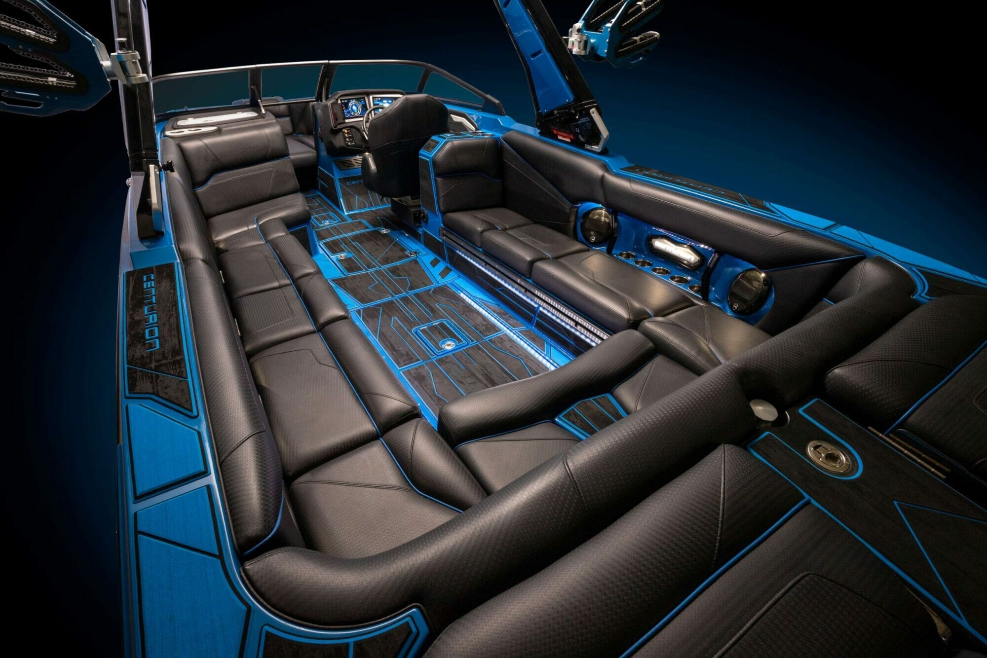 The interior of a blue and black wakesurf boat.