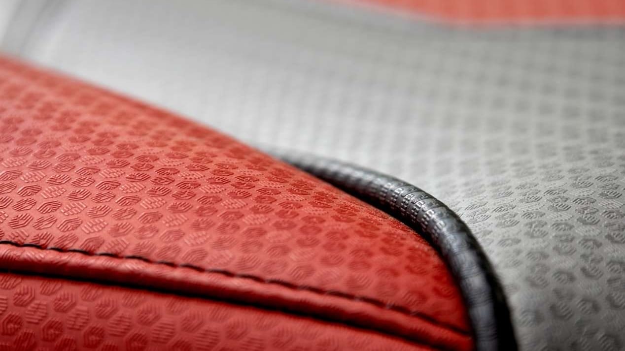 A close up of a red and grey leather seat in a wakesurf boat.