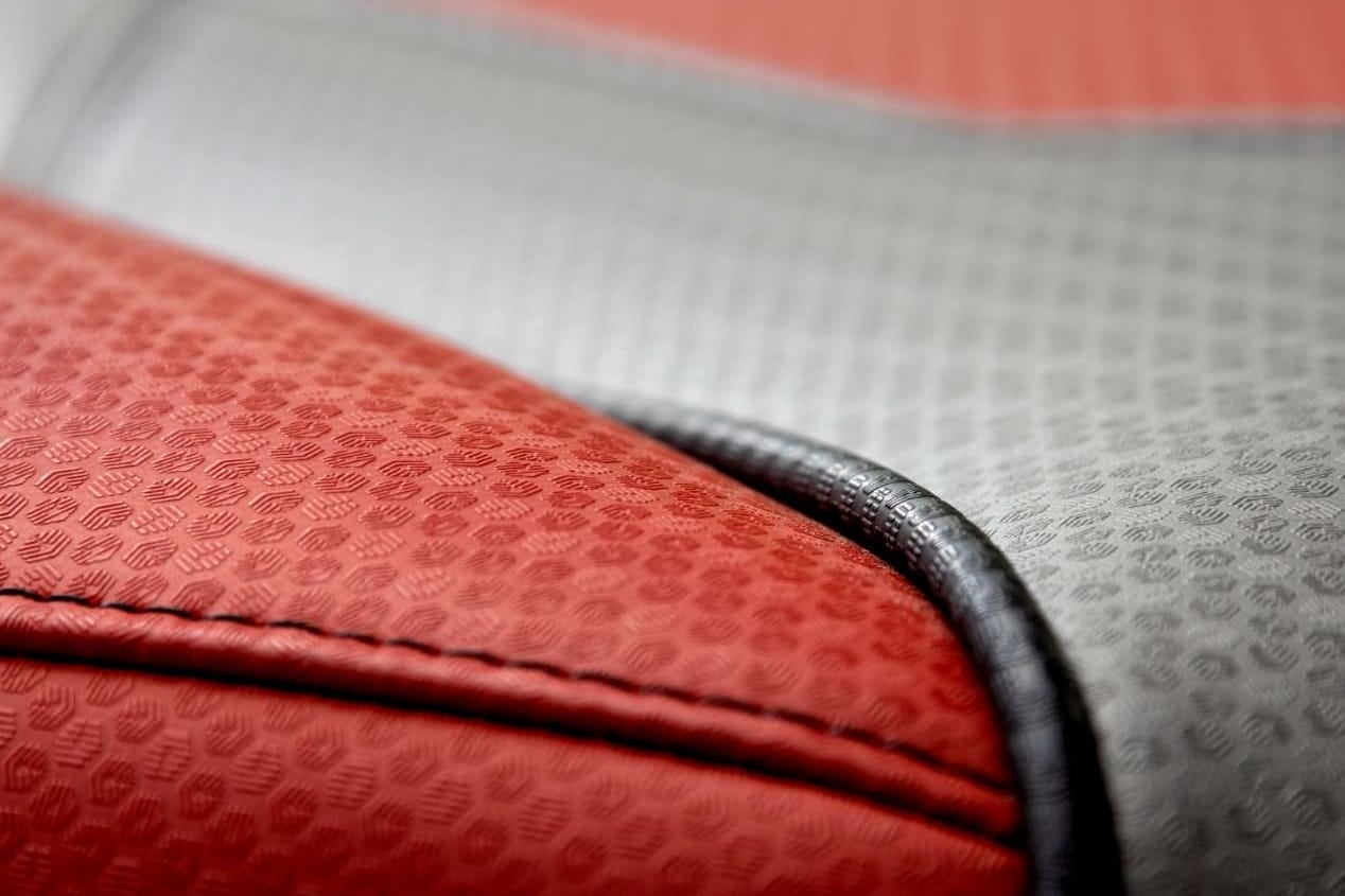 A close up of a red and grey leather seat in a wakesurf boat.