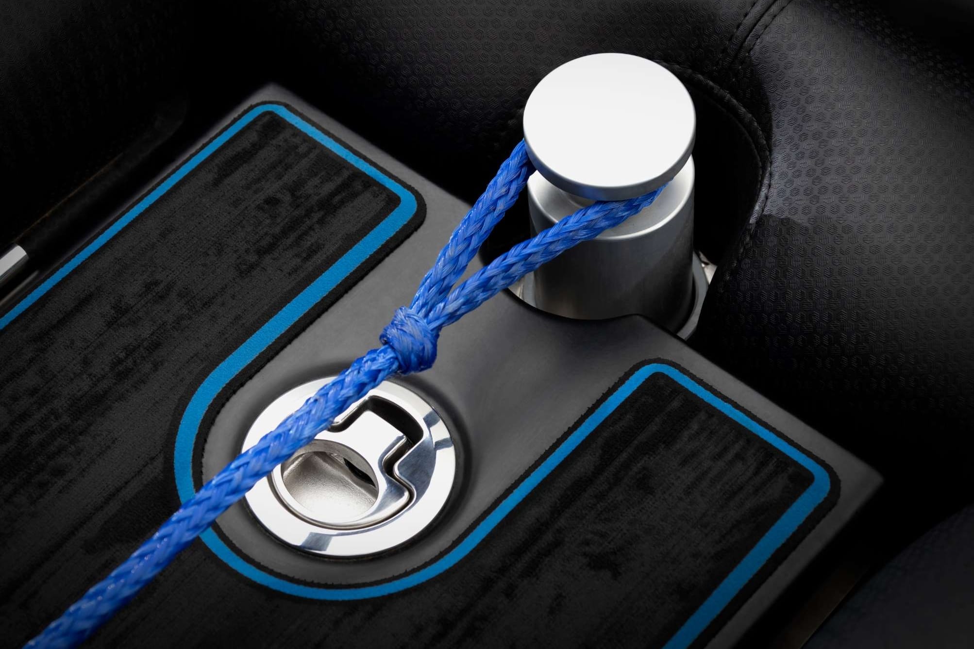 A rope is attached to a car's gear shifter, resembling wakesurf boat attachment.