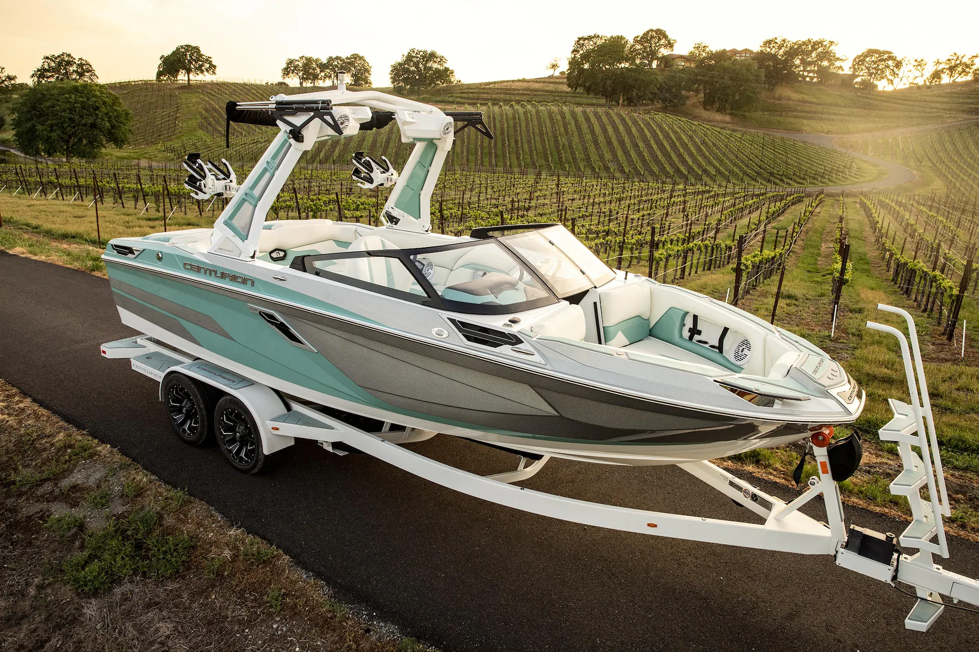 A wakeboat is parked on the side of a road.