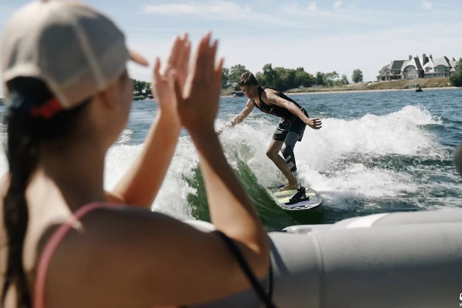 A woman is riding a wakeboard on a boat.