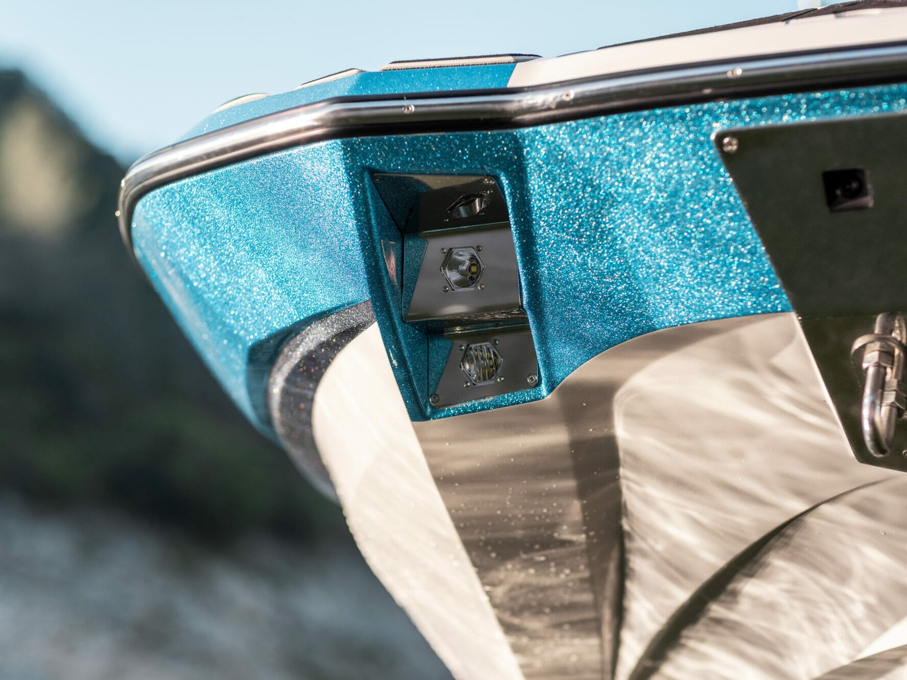 The front end of a wakesurf boat with a blue trim.