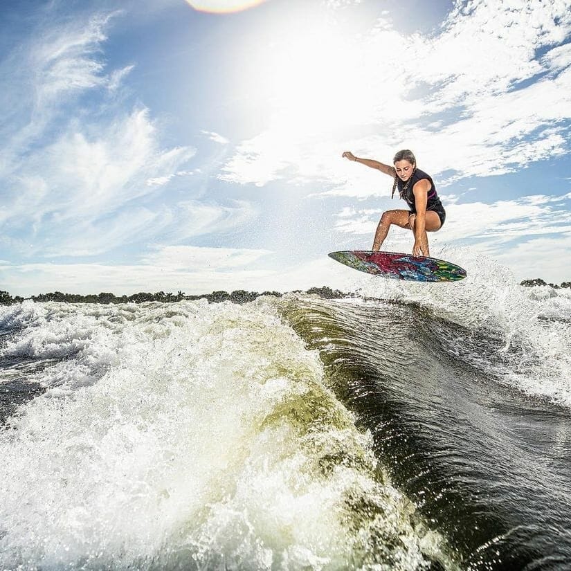 A woman is wakesurfing behind a boat.