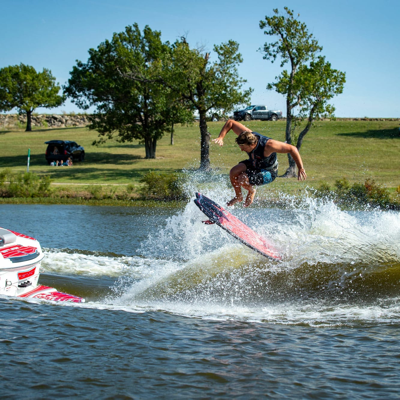 A man is wakesurfing behind a boat.