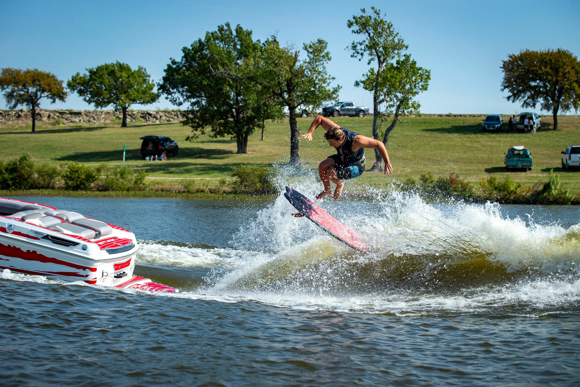 A man is wakesurfing behind a boat.
