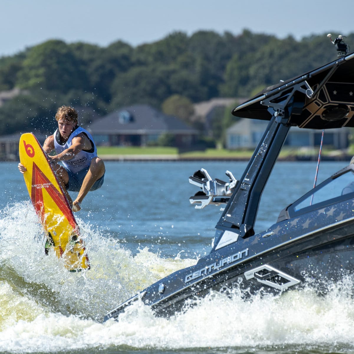A woman is wakesurfing on a wakeboat.