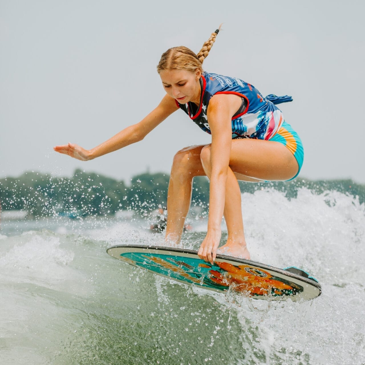 A woman riding a wave on a surfboard.