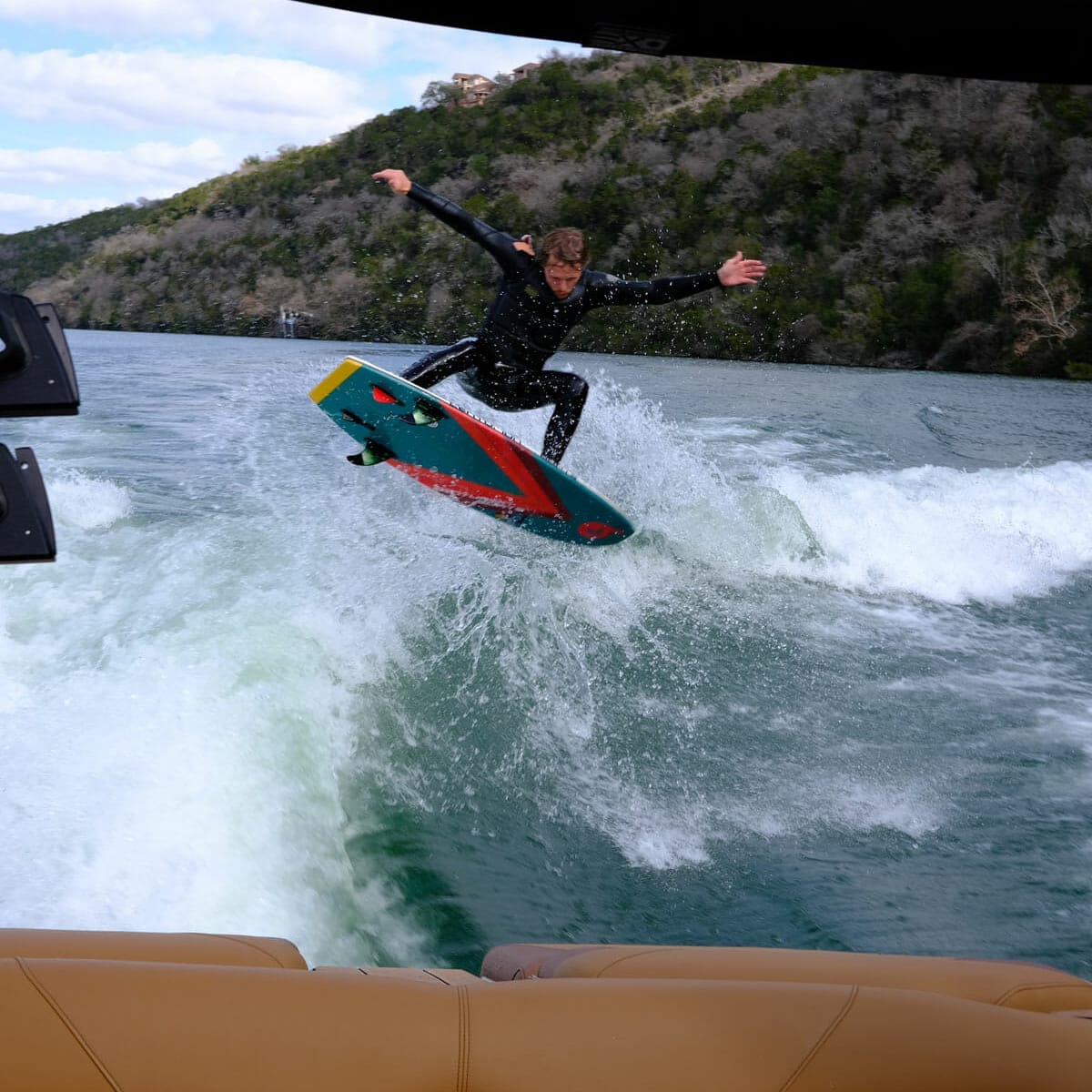 A man is riding a wakesurf board in the water.
