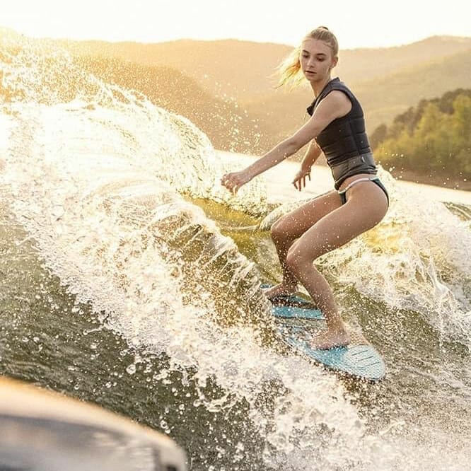 A woman riding a wave on a surfboard.