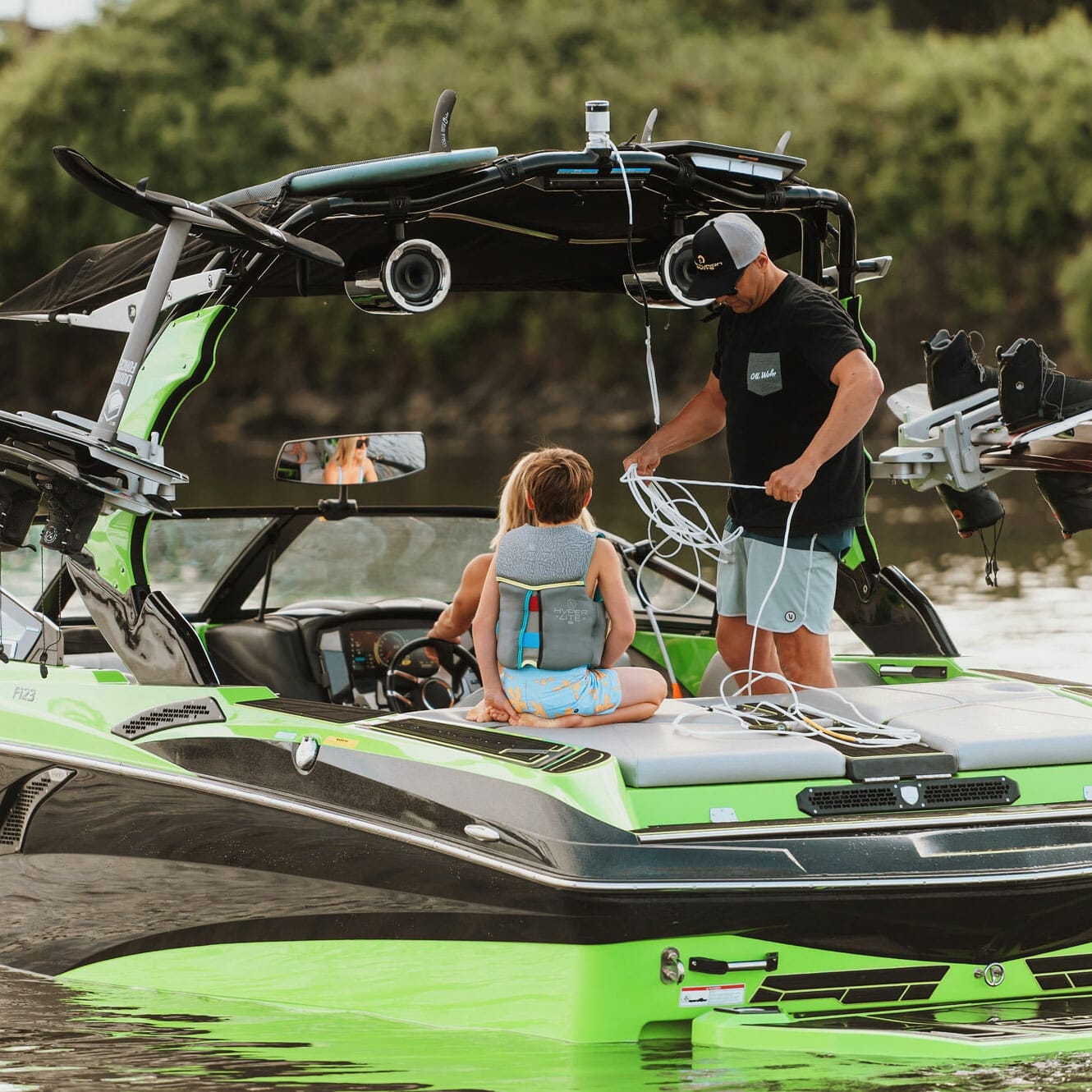 A man and a child on a wakesurf boat.