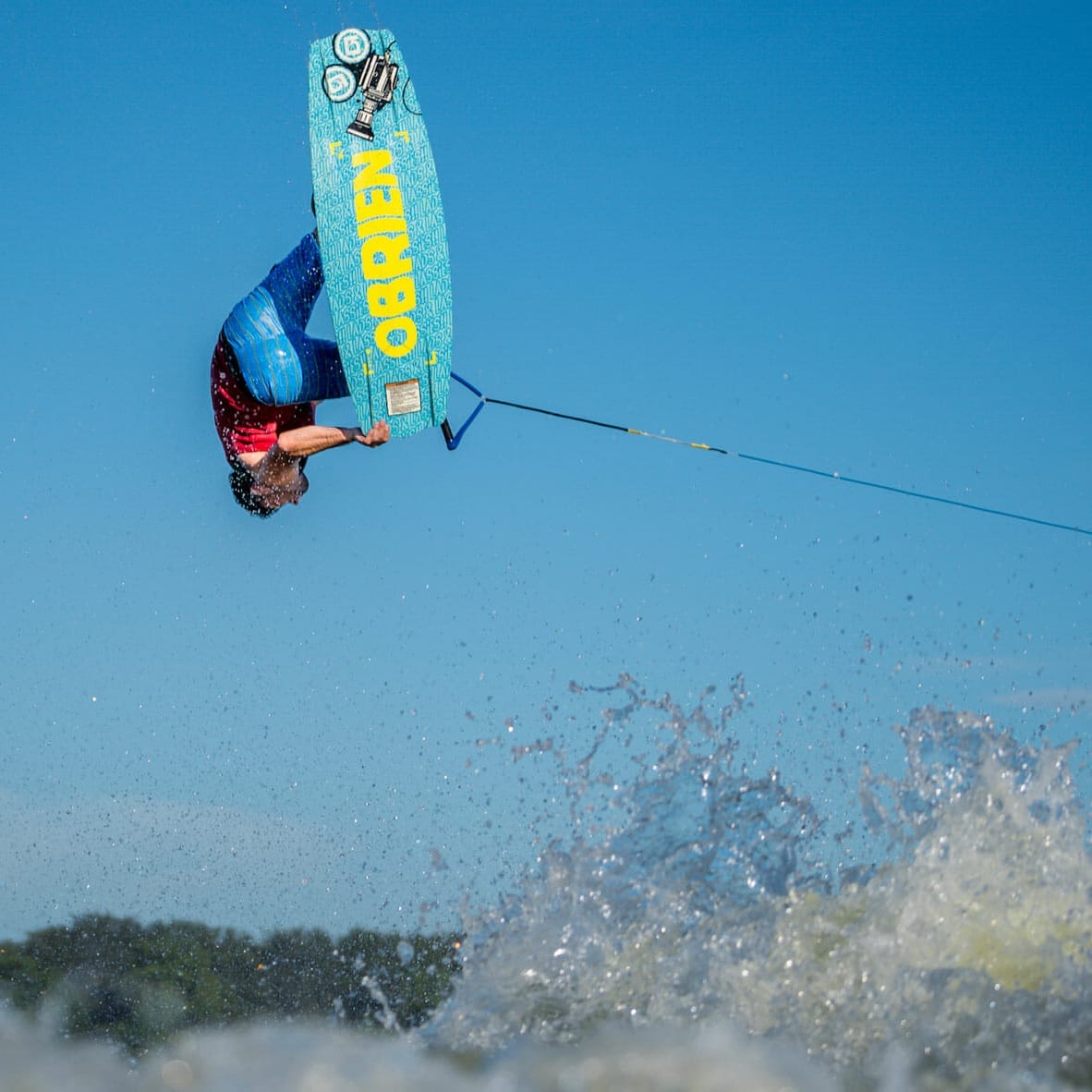 A man performing a trick on a wakesurf.