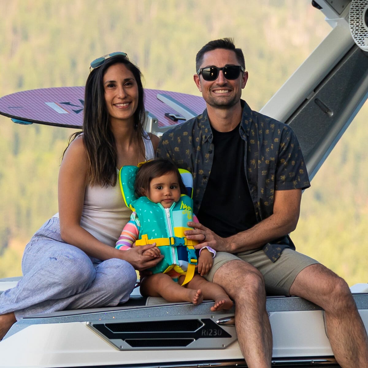 A couple with a baby on a wakeboat.