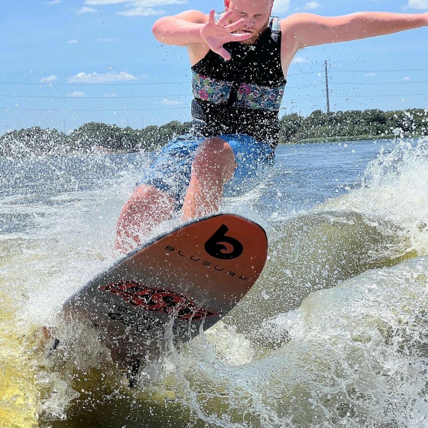 A man on a surfboard riding a wave with wakesurf board.