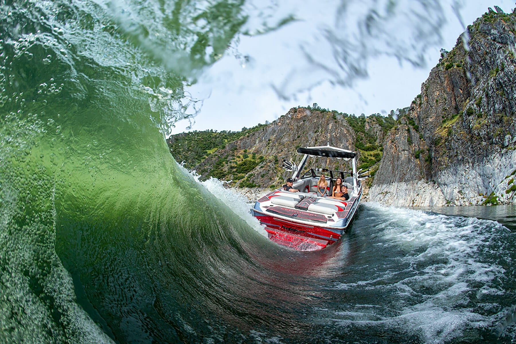 A wakesurf boat is going through a wave.