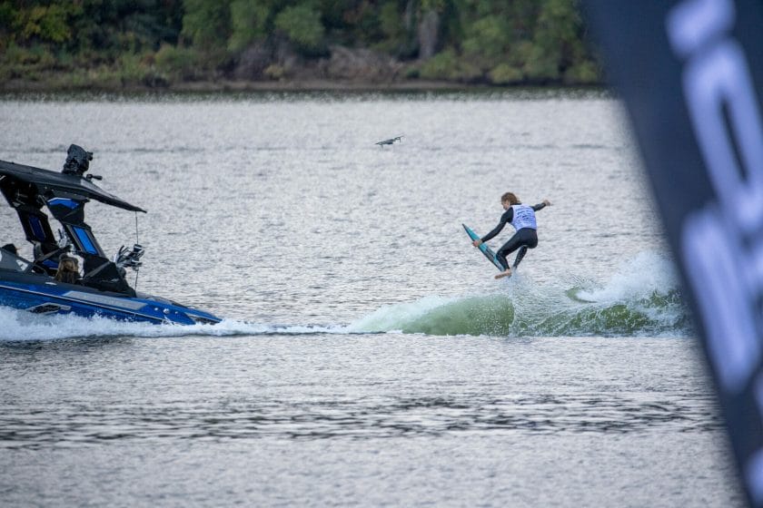 A man is riding a wakesurf board in the water.