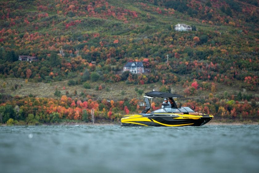 A yellow and black jet ski on a lake in the fall.