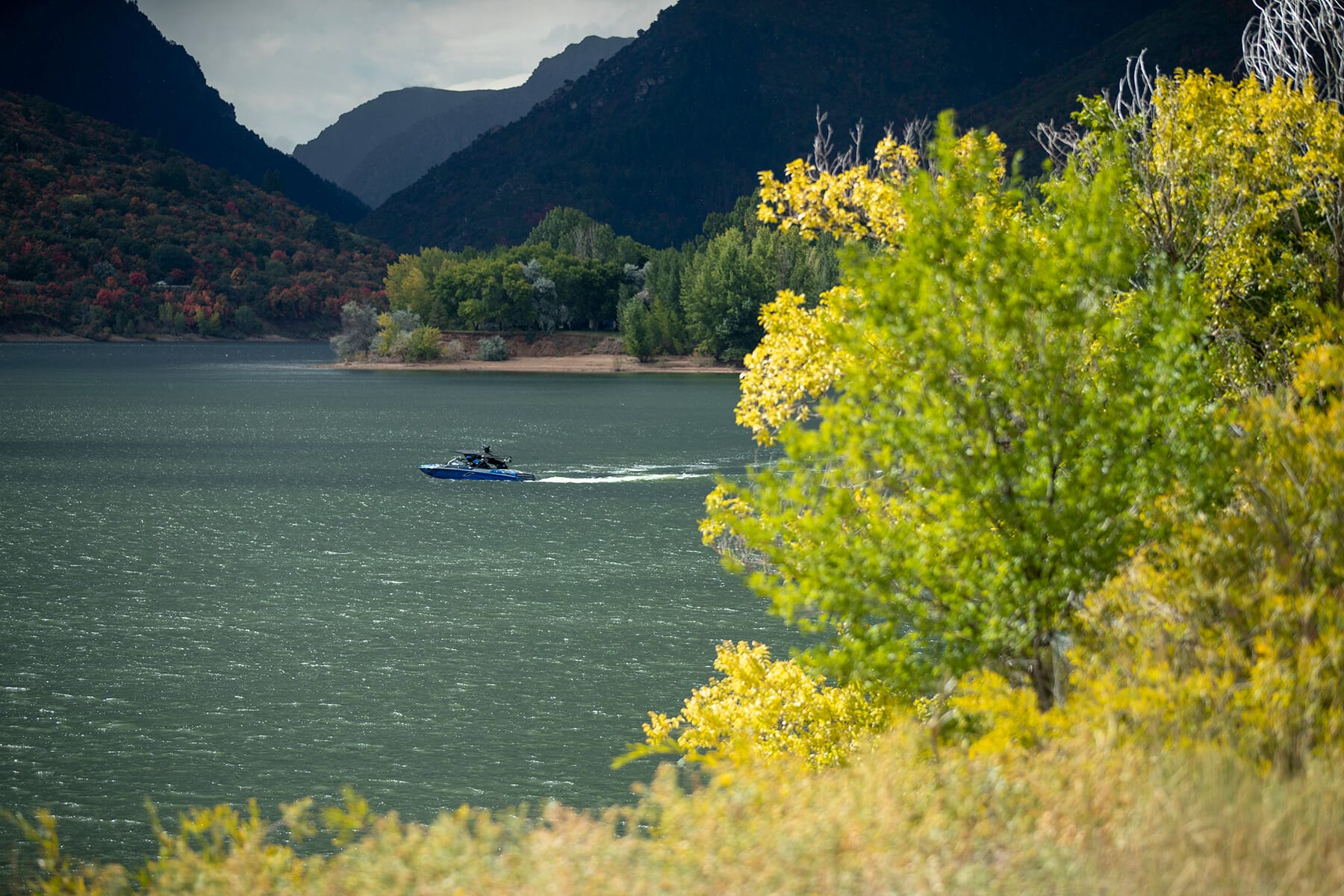 A boat on a lake near a mountain.