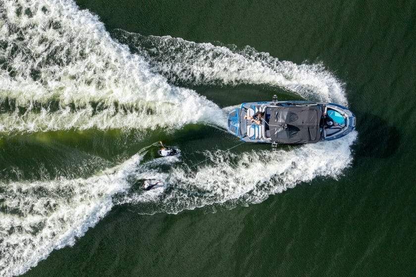 An aerial view of two people riding a boat in the water.