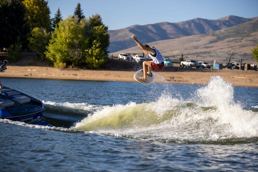 2024 WWSC Day 2 Recap: A man is surfing in the air over a boat.