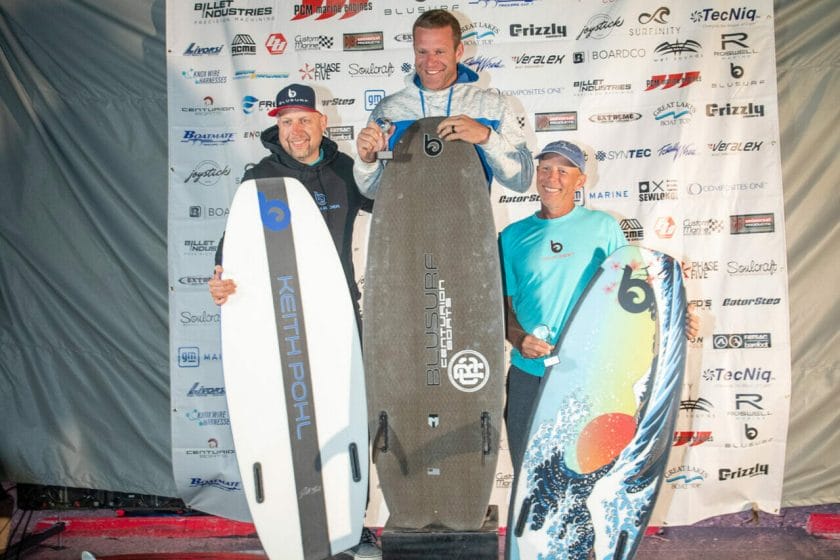 A group of people posing on Day 2 of the 2024 WWSC, with their surfboards.
