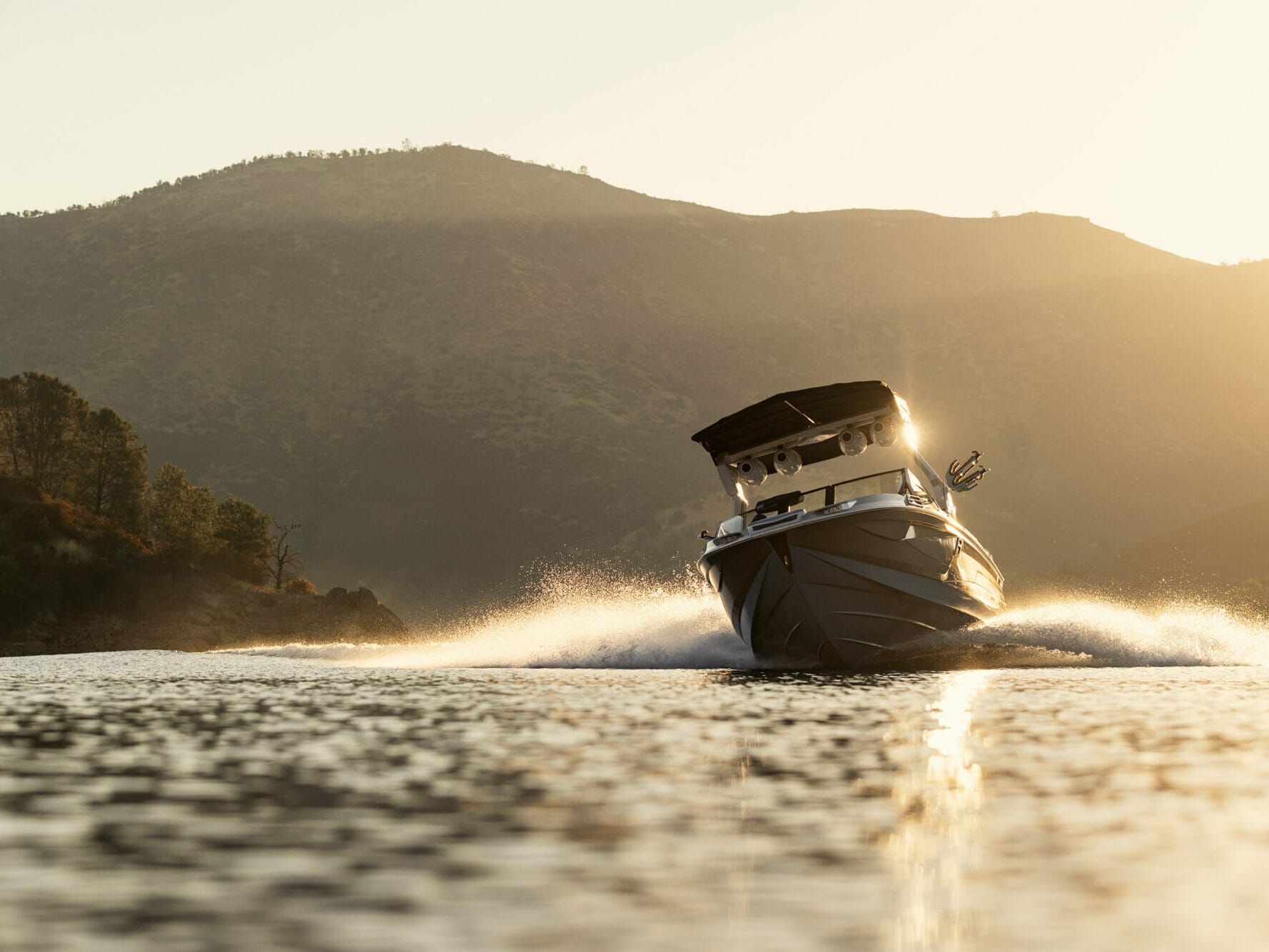 A wakesurf boat on a body of water.