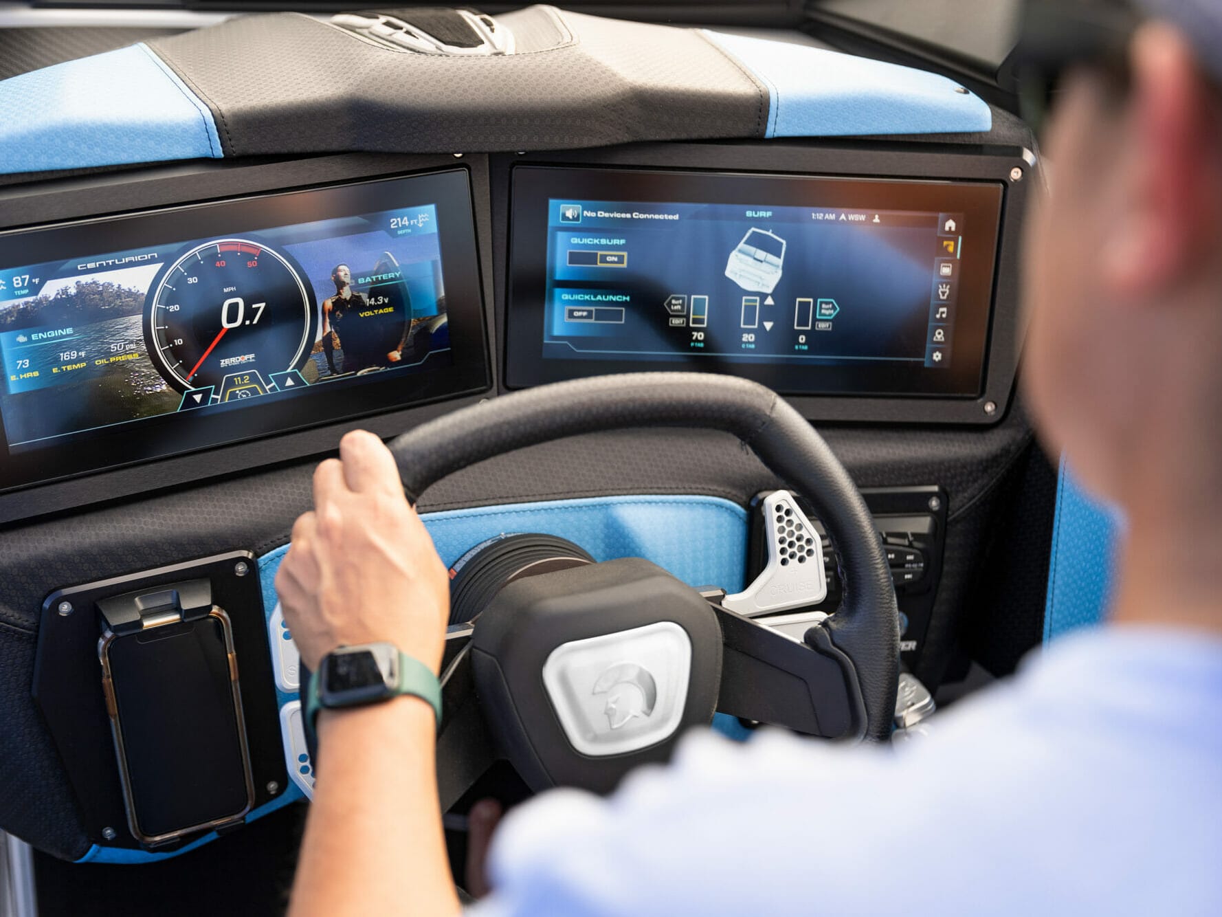 A man is driving a car with a touchscreen dashboard.
