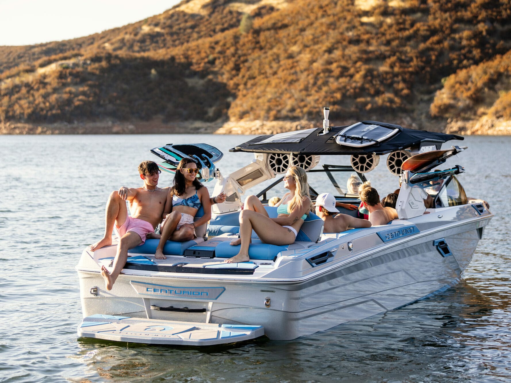 A group of people riding a wakesurf board on a wakeboat.