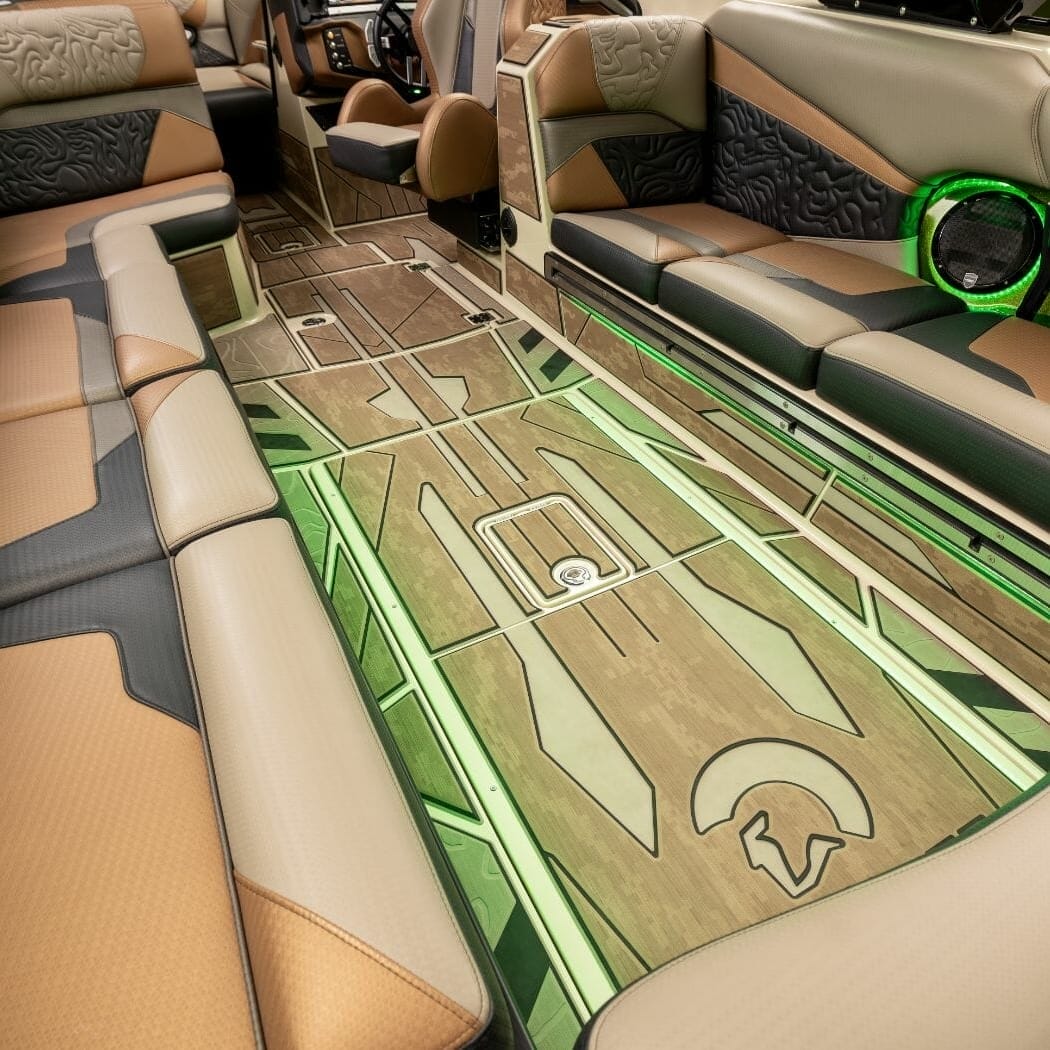 The interior of a wakesurf boat with a green leather seat.