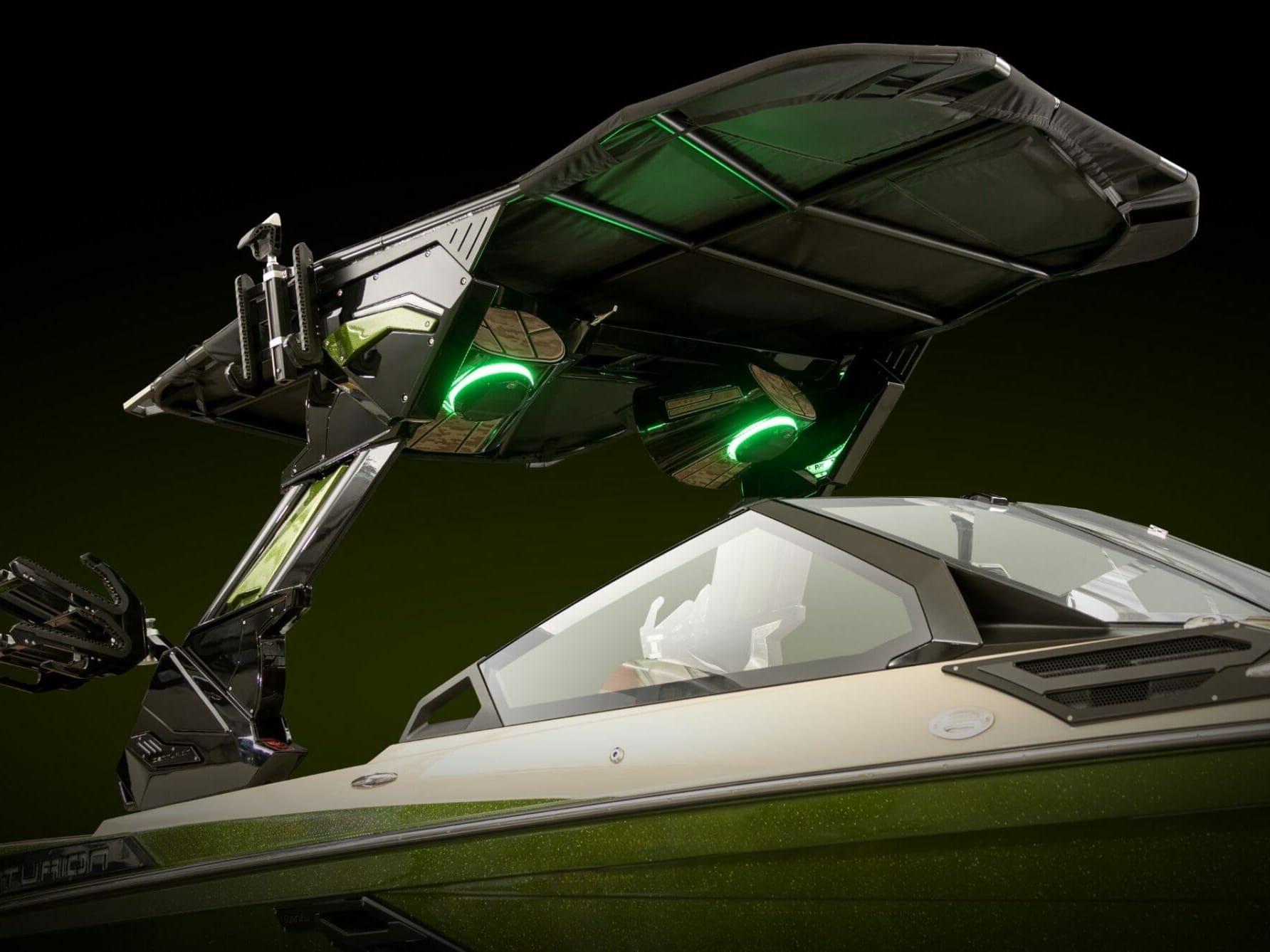 A wakesurf boat with a green light on top of it.