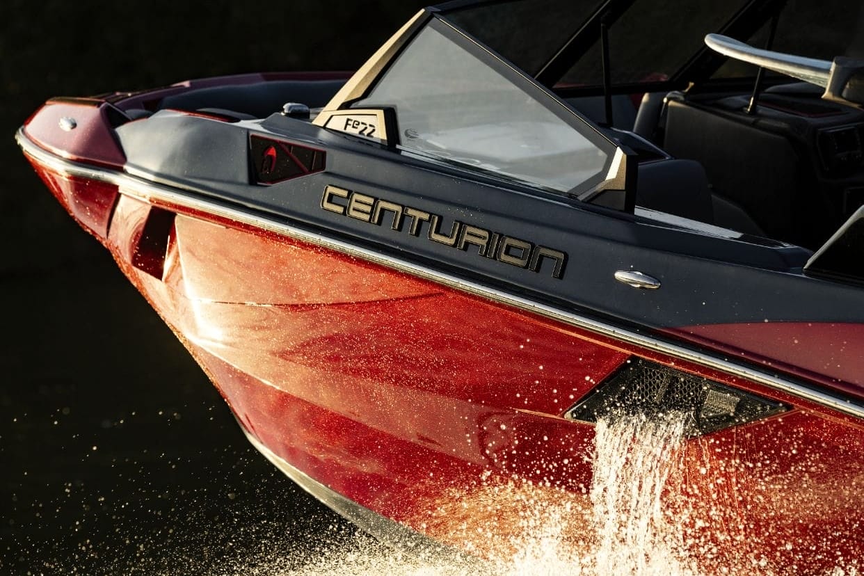 The Centurion Fe22, a red and black boat, is speeding through the water.