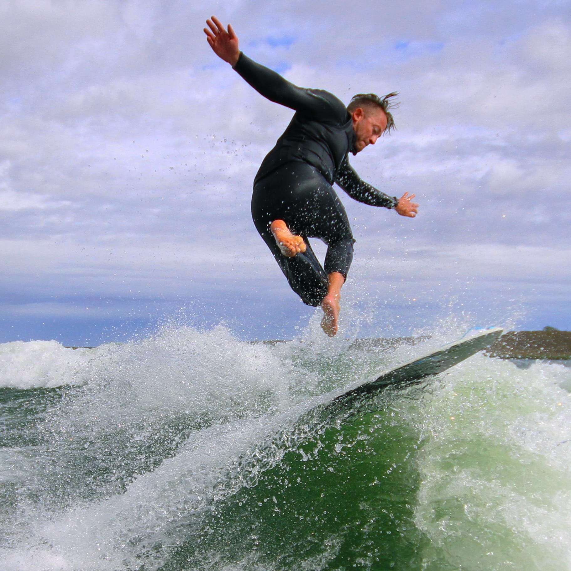 A man is riding a wave on a surfboard.
