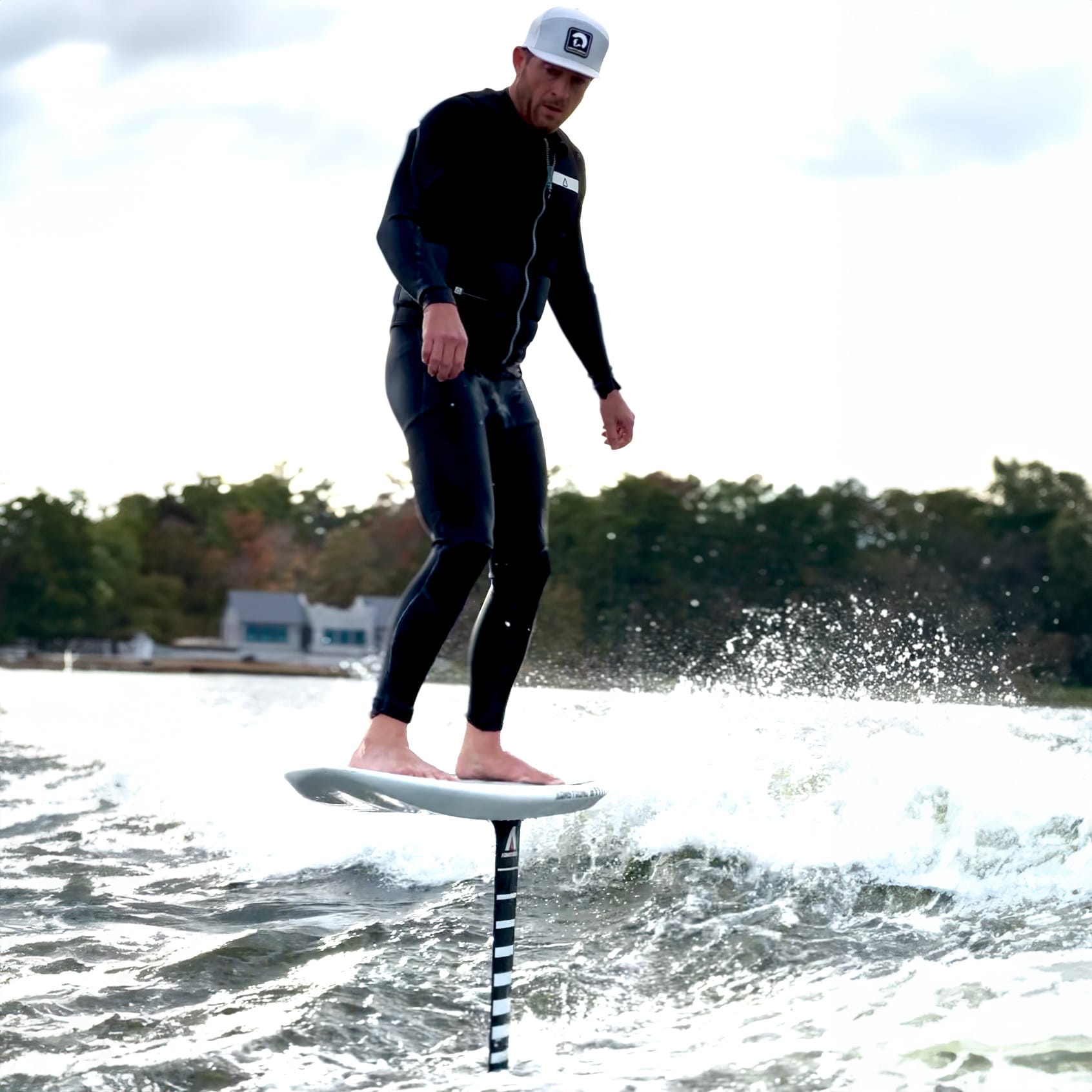 A man standing on top of a wakeboard in the water.