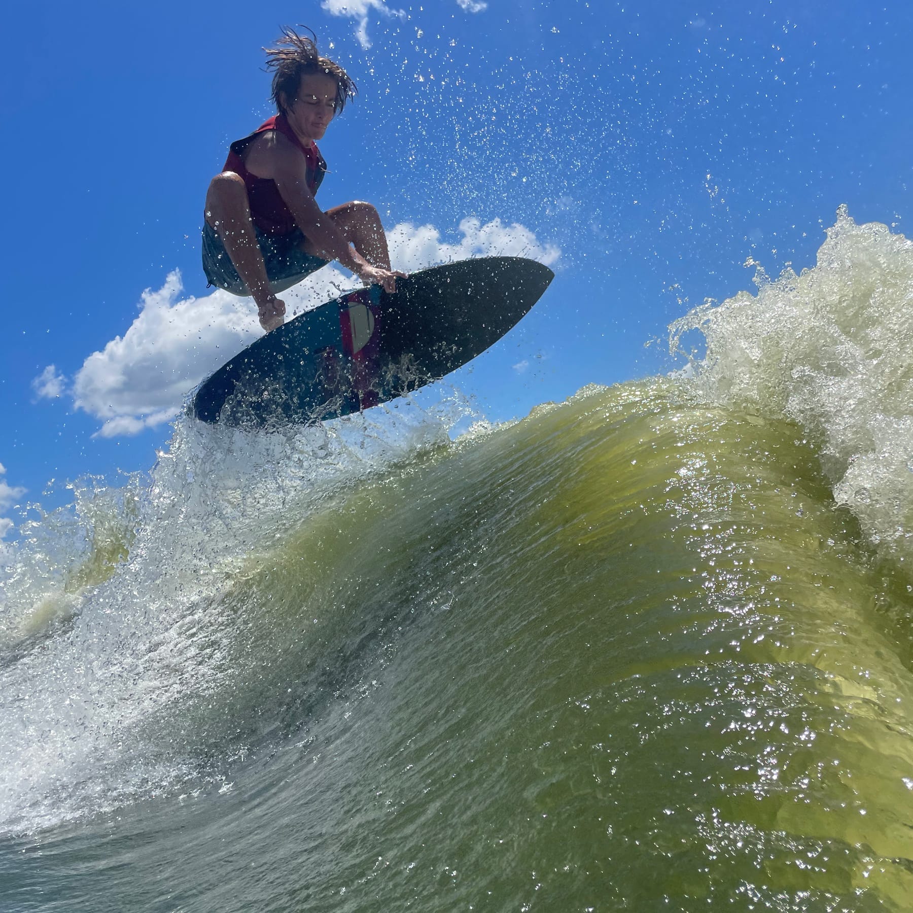 A young man riding a wave on a surfboard.