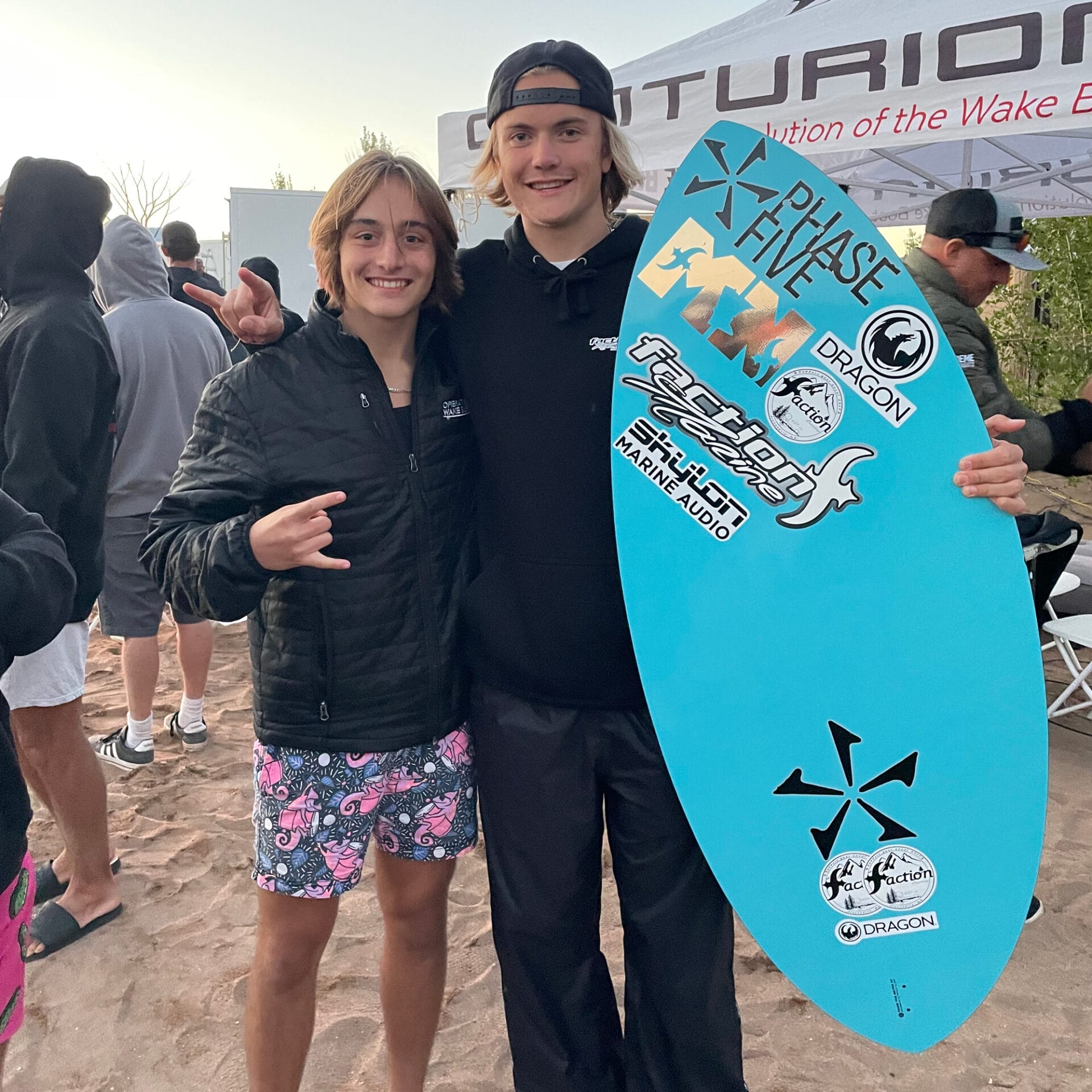 Cade Lybeck posing for a photo with a surfboard.