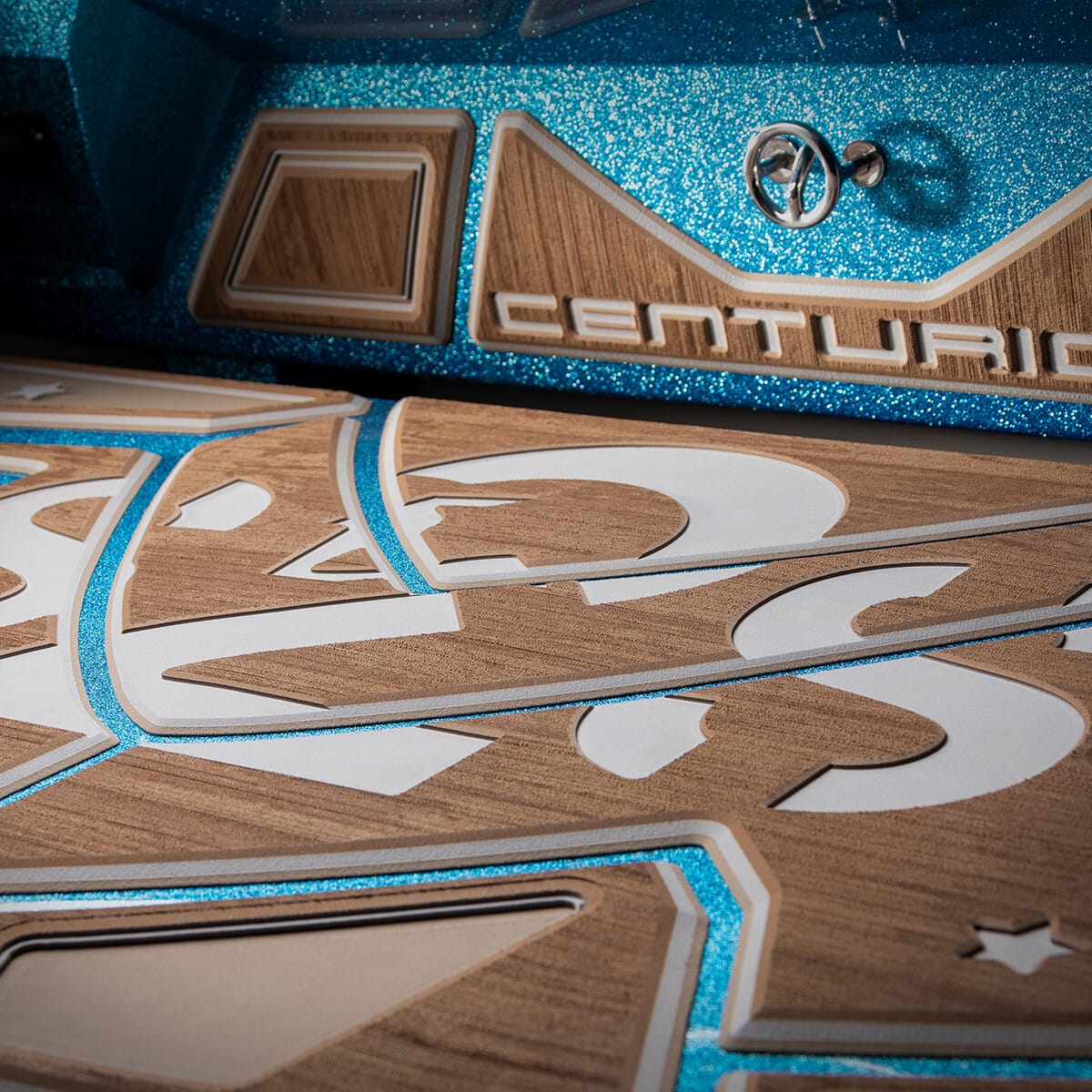 Close-up of a Centurion logo on a boat with a detailed wooden design and blue metal accents.